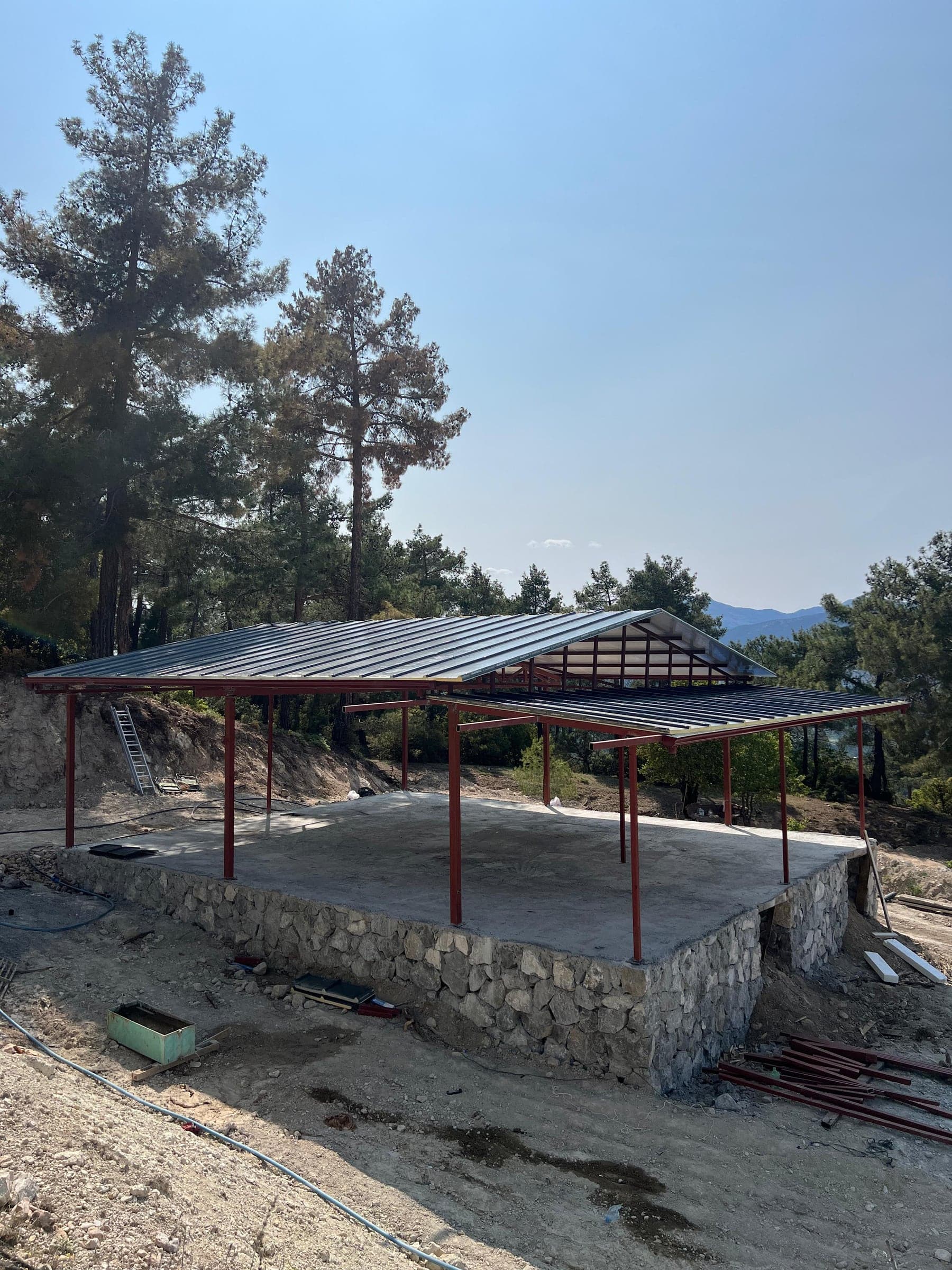 Çam ormanında taş kaide üzerine kurulan çelik pavyon