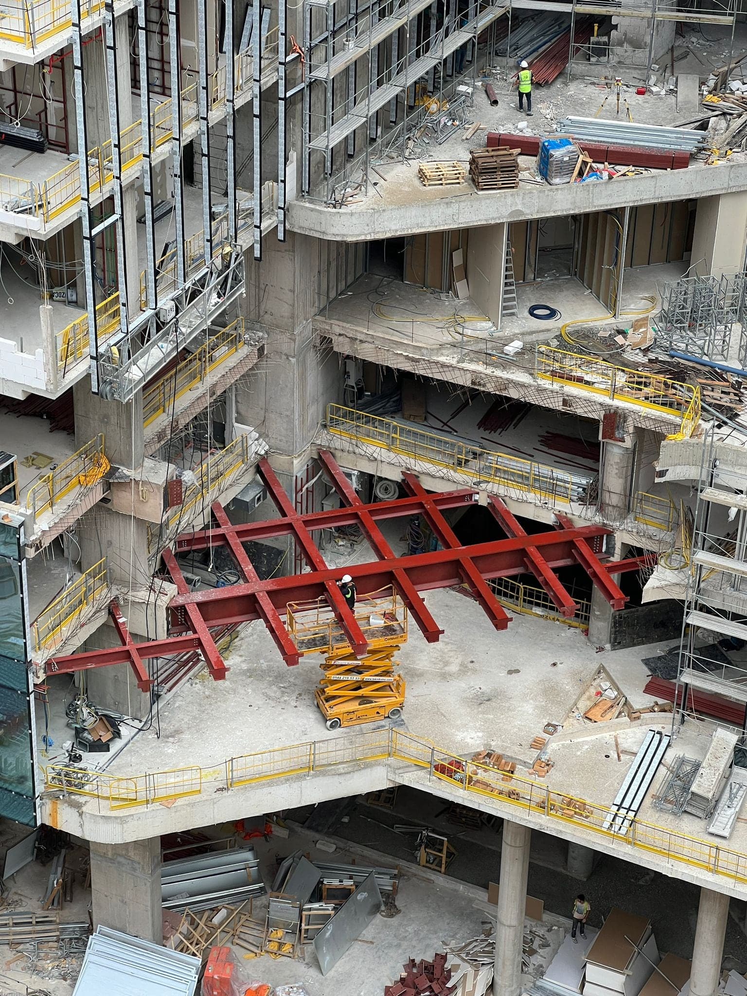 Yüksek binanın iç boşluğuna monte edilen kırmızı astarlı çelik kiriş ızgarası