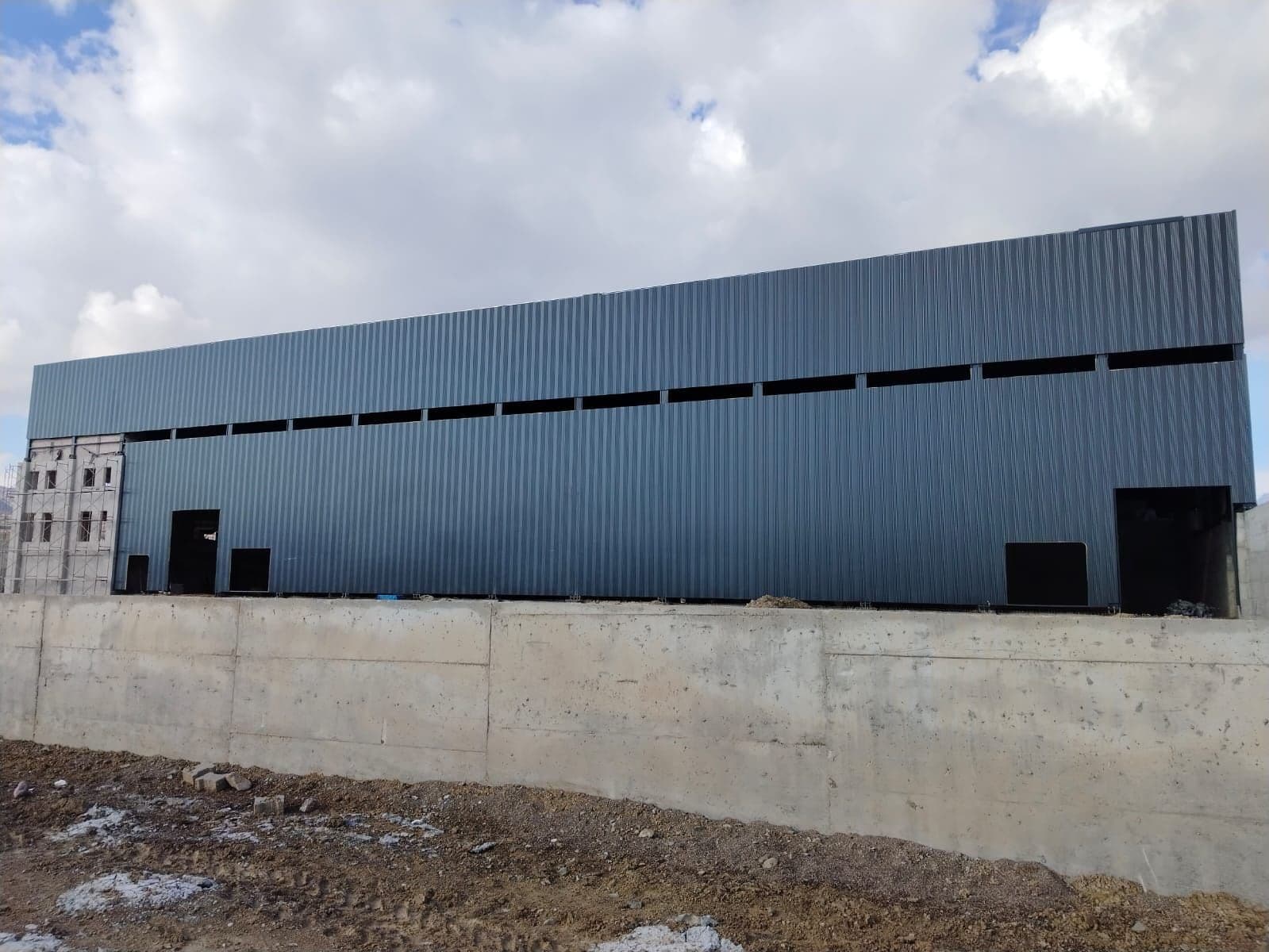 Gri metal panellerle kaplanmış fabrika binası